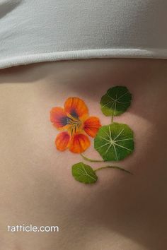 a woman's stomach with flowers and leaves painted on the side of her belly