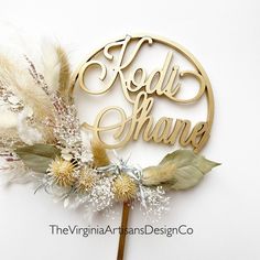 there is a cake topper with the words hello share on it and some feathers