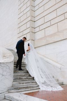 a bride and groom walking down the stairs