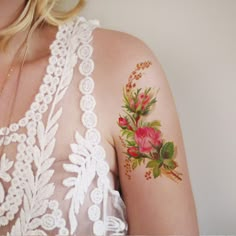 a woman with tattoos on her arm and shoulder is looking at the camera while wearing a white dress