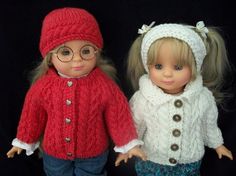 two dolls dressed in sweaters and hats are standing next to each other on a black background