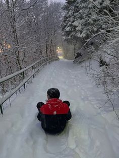 a person sitting in the snow on top of a sled