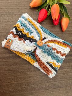 a crocheted headband and tulips on a table