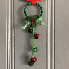 a door hanger with bells and ribbon hanging from it