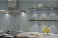 a kitchen with white counter tops and blue backsplash tiles on the back wall