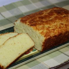 a loaf of bread sitting on top of a green and white plate next to slices of bread