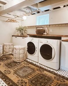 a washer and dryer in a laundry room with rugs on the floor