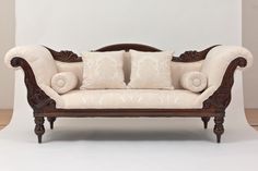 a white couch sitting on top of a hard wood floor next to a wooden frame