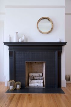 a fireplace in a living room with white vases on the mantle