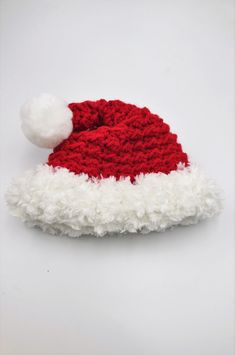 This is newborn crocheted sleeping hat that looks like a Santa hat.  This will fit a newborn is great for a photoshoot.  It is red and white and the to part with the round pompom is attached to the hat so it will not  move. Pattern by Daisy Farm Crafts  https://www.etsy.com/shop/daisyfarmcrafts White Crochet Hat For Winter Gift, Winter White Crochet Hat As Gift, Hand Knitted White Hat Gift, White Crochet Hat As A Gift, White Yarn Crochet Hat For Gift, White Hand Knitted Hat As Gift, White Yarn Crochet Hat As Gift, White Hand Knitted Hat Gift, Handmade White Crochet Hat For Gift