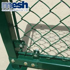 a close up view of a green chain link fence with two screws on it