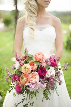 a bride holding a bouquet of flowers in her hands and looking at the camera with an intense look on her face