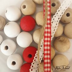 several wooden beads and lace on a white plate with red and white checkered ribbon