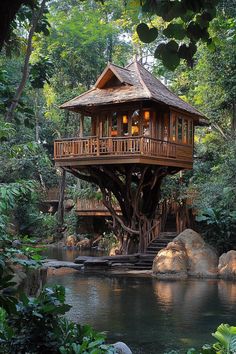 a tree house built into the side of a body of water with trees around it