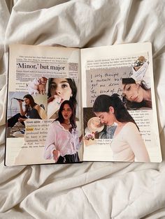 an open book with pictures of women on it sitting on top of a white sheet