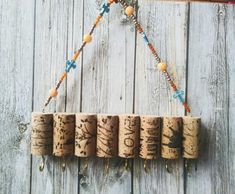 a group of wine corks hanging from a string on a wooden wall with beads