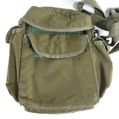 the back pocket of a green bag on a white surface with a strap around it