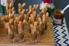 there are many churros in small glasses on the table