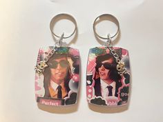 two keychains with pictures of people wearing sunglasses and tie, one has a name tag attached to it