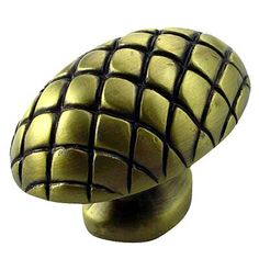 an antique brass finish knob with black squares on the front and back end, is shown