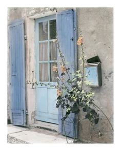 an old building with blue shutters and flowers growing out of the window sill