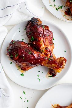 two white plates topped with meat covered in sauce