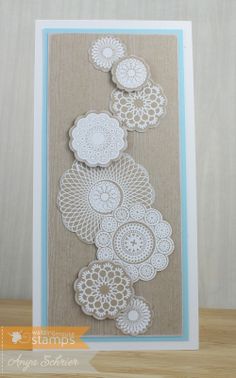 a card with white doily on it and blue trim around the edges, sitting on a wooden table