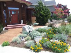 a house with flowers and rocks in the front yard