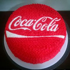 a coca - cola cake with red frosting and white icing on a table