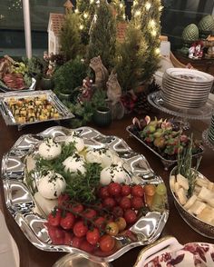 a table filled with lots of food on top of metal trays and bowls full of vegetables