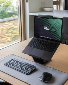 an open laptop computer sitting on top of a wooden desk next to a mouse and keyboard