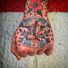 a man's hand with a tattoo on it that says work, play and class