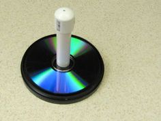 a black disk with a white top and a blue disc in the center on a table