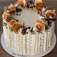 a white cake with oranges and cinnamon on top