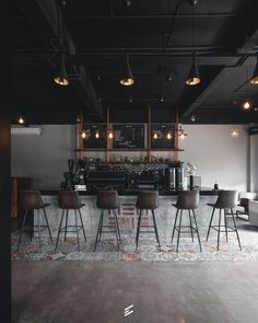 a bar with stools and tables in an industrial style restaurant or coffee shop area