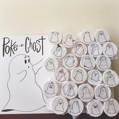 a bunch of buttons with ghost faces on them next to a sign that says poke - a - ghost