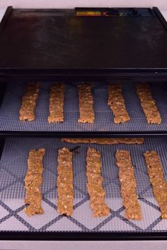 two trays filled with food sitting on top of a stovetop burner next to each other