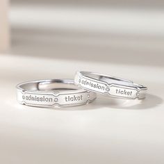 A gorgeous Custom Engravable Couple Rings Set for two is an open ended/adjustable size rings set, its inner round edges make it suitable for everyday wear. Personalized the rings set with names or any text of your choice in local languages and unique symbols which make the rings a unique promise/commitment or wedding anniversary gift for men and women.Material: Anti-allergic White Gold Plated 925 Sterling Silver + Cubic Zirconia (admission ticket engraved on the ring is part of the design and it Personalized Silver Open Midi Rings, Custom Text Silver Jewelry For Promise Ring, Customizable Silver Couple Rings, Personalized Silver Jewelry For Proposal, Adjustable Engraved Silver Couple Rings, Personalized Sterling Silver Couple Rings With Open Design, Personalized Sterling Silver Open Couple Rings, Engraved Adjustable Open Couple Rings, Adjustable Engraved Couple Open Rings