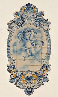 an ornate blue and white tile with cherubs on the border is featured in this image