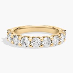 a yellow gold ring with five stones on the side and three rows of diamonds in each band