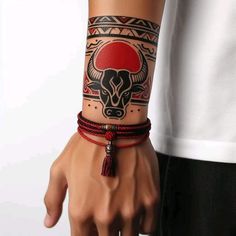 a man wearing a red and black bracelet with a bull head on it's wrist