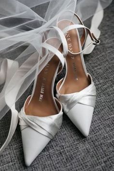 the bride's wedding shoes and veil are sitting on the floor next to each other