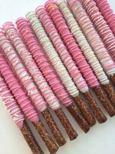 there are many pink and white donuts in the shape of candy sticks with sprinkles on them