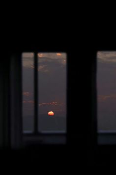 the sun is setting through some windows