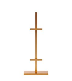 a wooden cross stands on a stand against a white background