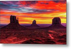 the sun is setting over monument buttes in monument national park, utah with a river running through it