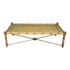 a bamboo coffee table with two legs and a tray on it's top, against a white background