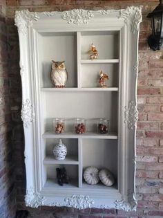 an owl is sitting on top of a white shelf in front of a brick wall