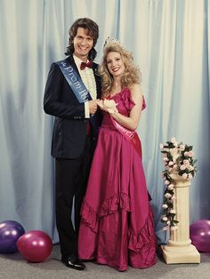 a man in a tuxedo standing next to a woman in a pink dress