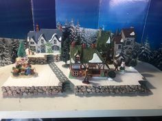 a model of a small town with trees and snow on the ground in front of it